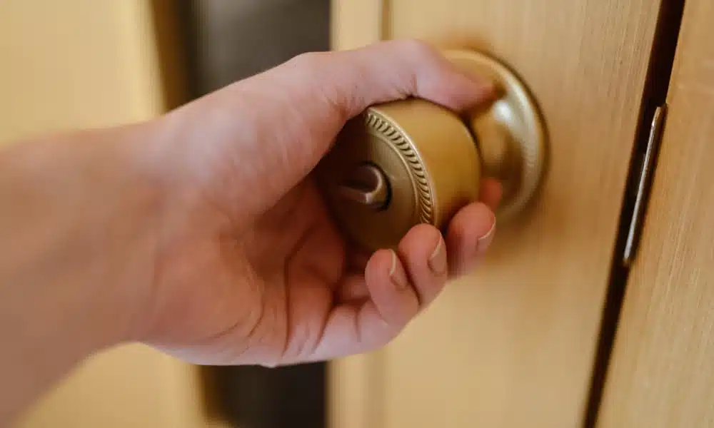 a person opening a door that sticks