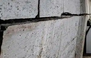 Visible cracks and bowing basement wall, a clear signs of a sinking foundation in Fairfax, VA.