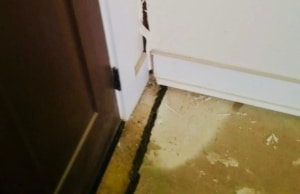 Deep floor cracks spreading from a basement door frame, indicating significant cracks in basement floor in Harpers Ferry, WV.