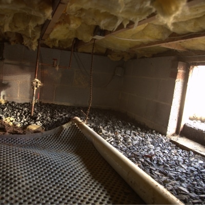 A crawl space drainage installation in Southbridge, VA, an effective solution to mitigate wet crawl space insulation.