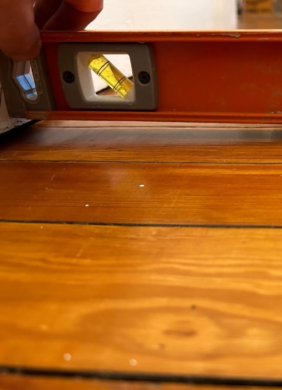 Measuring tool on the floor showing uneven floors, a sign of foundation problem that needs fixing unlevel floors in Bristow, VA.