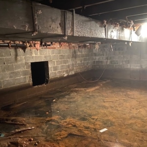 A crawl space with standing water, showing flooding as a significant cause of a musty odor in Southbridge, VA.