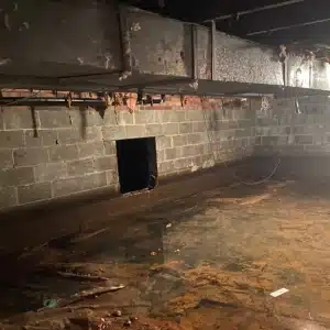 A crawl space with standing water, showing flooding as a significant cause of high humidity in crawl space in Charles Town, WV.