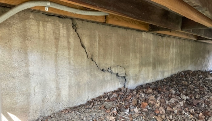 Crawl space with a significant line of foundation crack in Northern Virginia, a symptom of underlying crawl space problems.