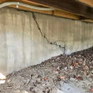 A crawl space foundation wall with visible cracks, showing foundation cracks that cause cold floor in Flint Hill, VA.