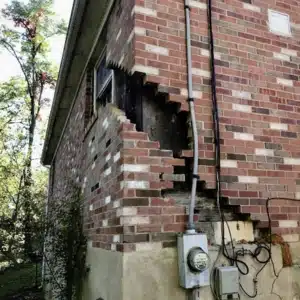 A house foundation with a deep, zigzag crack, showing how foundation settlement can cause drywall cracks in Flint Hill, VA