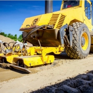 A bulldozer compacting soil, emphasizing improperly compacted fill soil as a cause of unlevel floor in Brambleton, VA.
