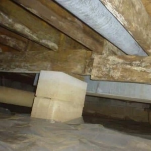 A crawl space with not properly sized joist and beam indicates insufficient support as a cause of floor sagging in Southbridge, VA.