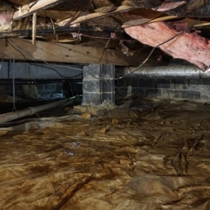 A damp and muddy crawl space caused by a stack effect that can cause floor sagging in Harpers Ferry, WV.