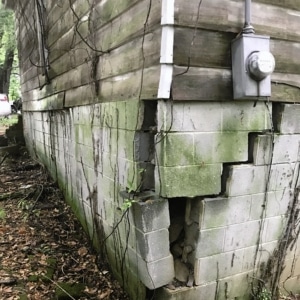 A damaged, cracked foundation, showing structural movement as the cause of cracks in concrete walls in Harpers Ferry, WV
