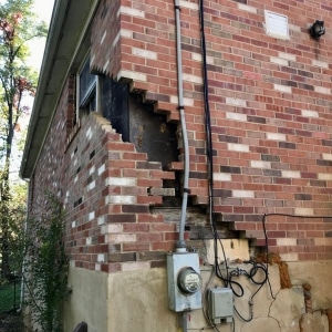 A foundation with big cracks due to structural settlement, as a primary cause of unlevel floor in Warrenton, VA.