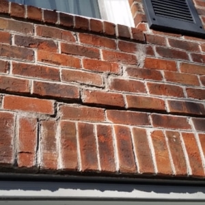 A cracked foundation brick wall, illustrating structural shifts as a cause of sticking doors and windows in Harpers Ferry, WV.