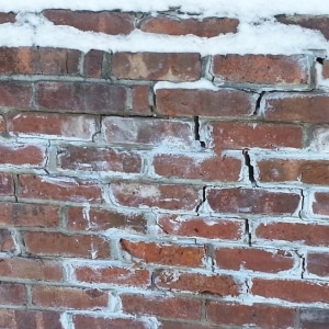 A foundation wall bricks with cracks and deformations, a temperature changes as the cause of mortar cracks in Ashburn, VA