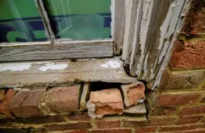 A deformation or warped wood in a window frame, a warped wood as a visible sign of rotting wood in Alexandria, VA.
