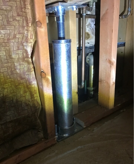 A robust and adjustable crawl space support post in Southbridge, VA to permanently lift and stabilize crawl space foundation.