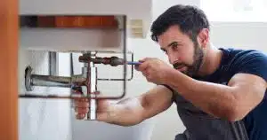 A plumber fixing sink pipe for rental property plumbing maintenance in Harpers Ferry, WV.