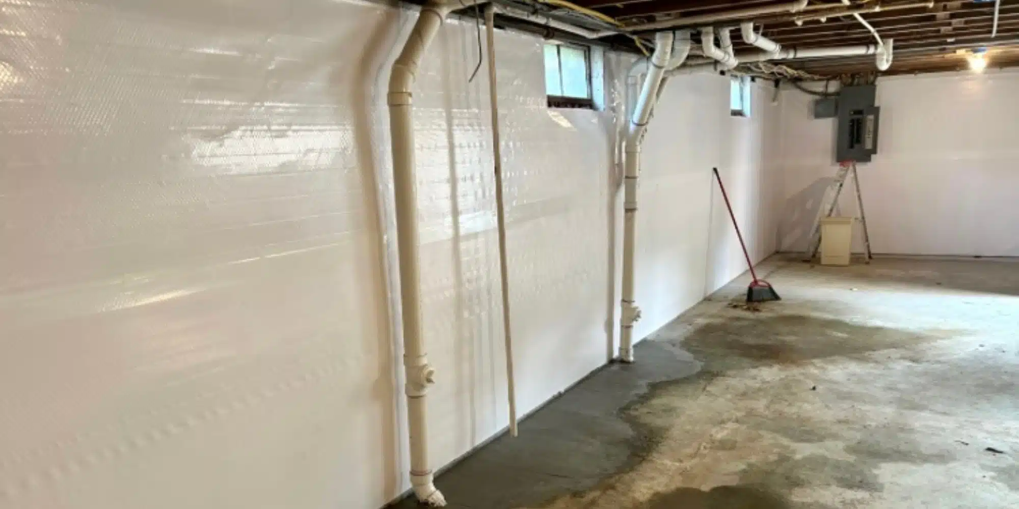 Basement wall with vapor barrier installation in White Post, VA, to prevent moisture infiltration.