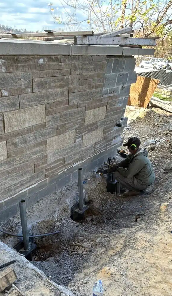 Image of LUX team performing push piers installations in Charles Town, WV, for structural support.