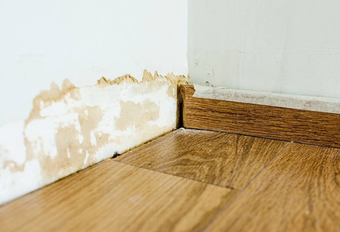 Basement wood paneling warped and buckled due to moisture damage.