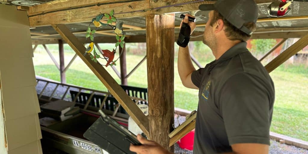 A licensed inspector examining house beams during a thorough home foundation inspection.