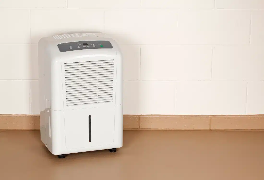 A dehumidifier running in a basement to reduce humidity and prevent mold growth.