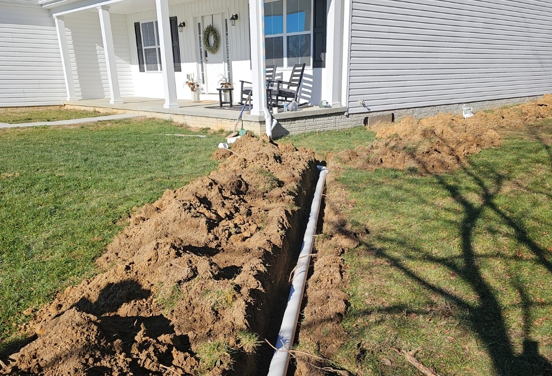 Photo of a finished downspout extension installation attached to a gutter, directing water away from the foundation.