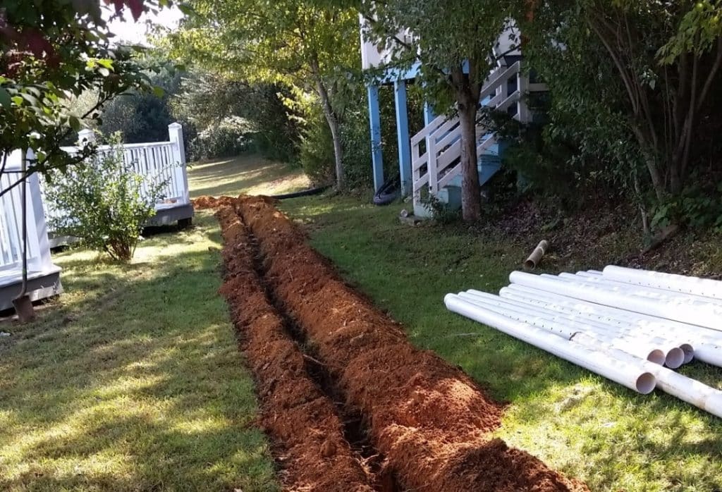 A land excavated for a French drain system around a home's foundation.