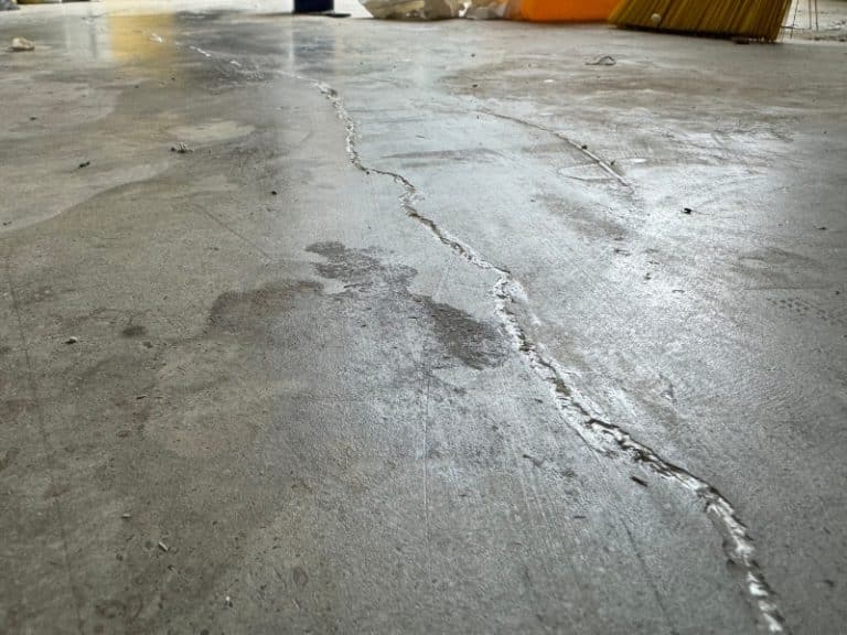 Technician applying Polyflex sealant to cracks in the concrete slab for concrete caulking repair in Front Royal, VA.