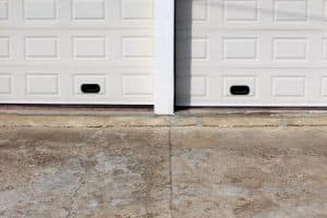 A garage door misalignment caused by floor settlement and concrete cracking, a sign of cracked garage floor in Ashburn, VA.