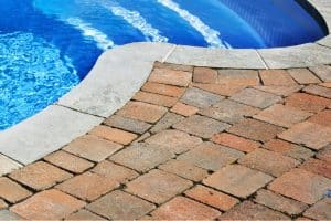 Wobbling or loose pavers on a pool deck, sign of a sunken pool deck in Bristow, VA need of concrete repair and stabilization.