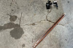 Moisture seeping through floor cracks, potential water damage, and a sign of cracked garage floor in Fairfax, VA.