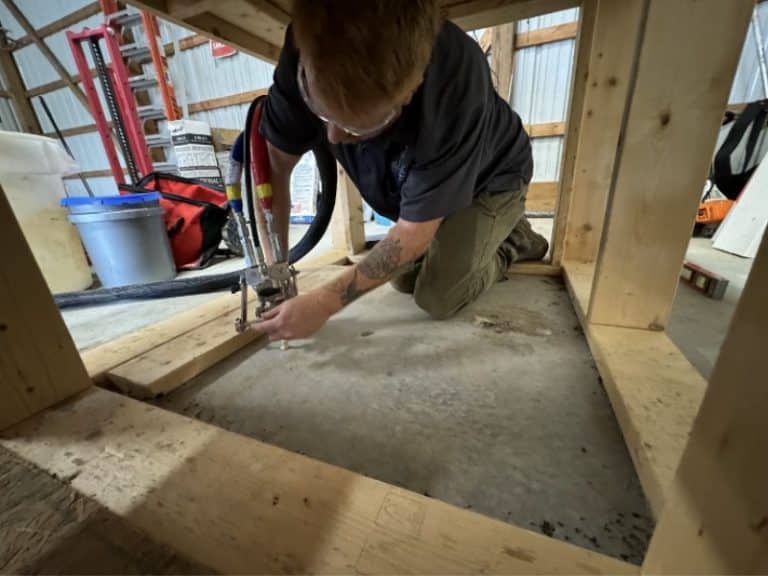 Polyurethane foam injection under a concrete slab to lift and level the uneven floor for concrete repair in White Post, VA.