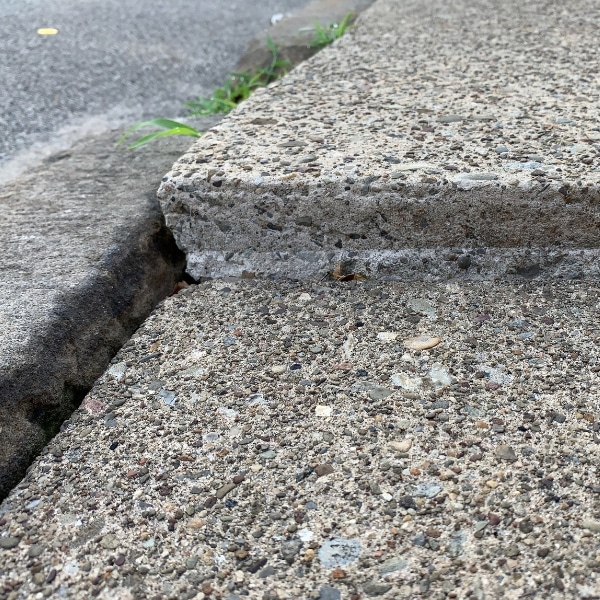 Sinking concrete surface section, illustrating soil settlement as a cause of uneven sidewalks and walkways in Marshall, VA.