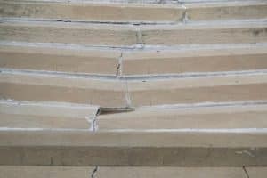 Sinking and cracking concrete porch steps, a sign of structural issues and sunken porch in Ashburn, VA, due to concrete problems.