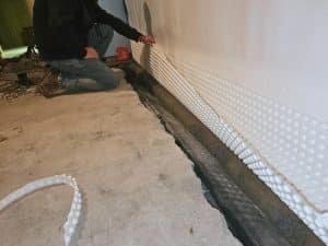 Installation of under-slab drainage system for basement waterproofing in Clear Brook, VA.