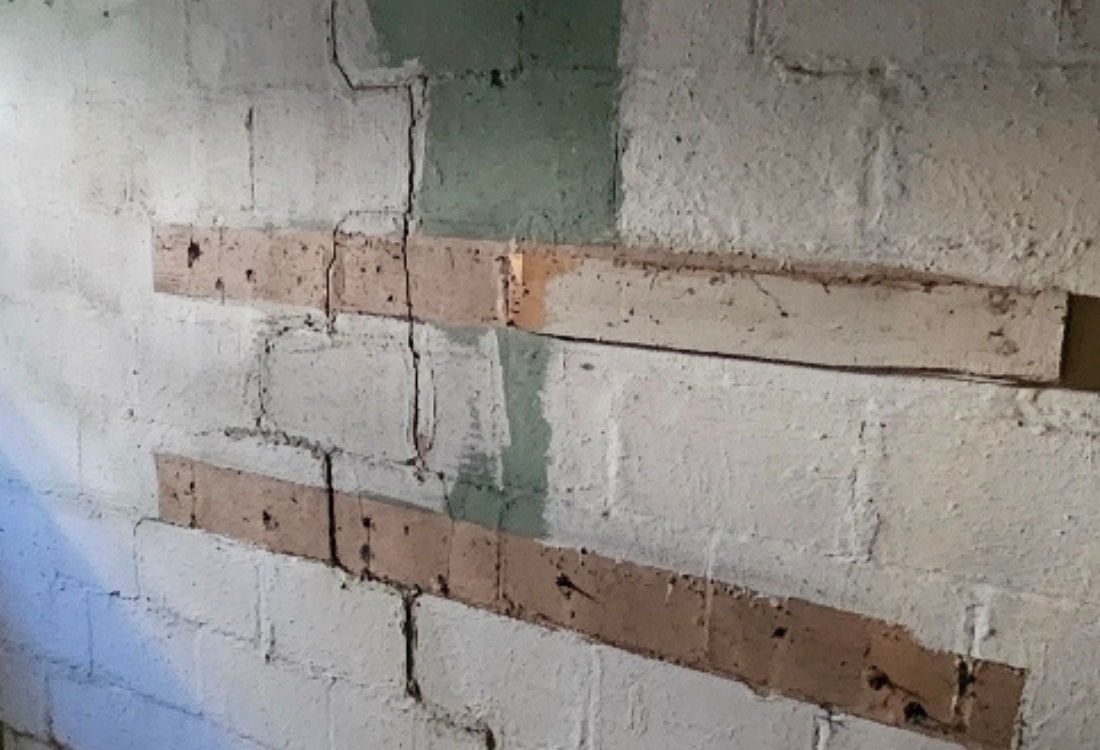 Cracked and bowed basement walls caused by soil pressure before foundation wall anchors installation in Stephens City, VA.