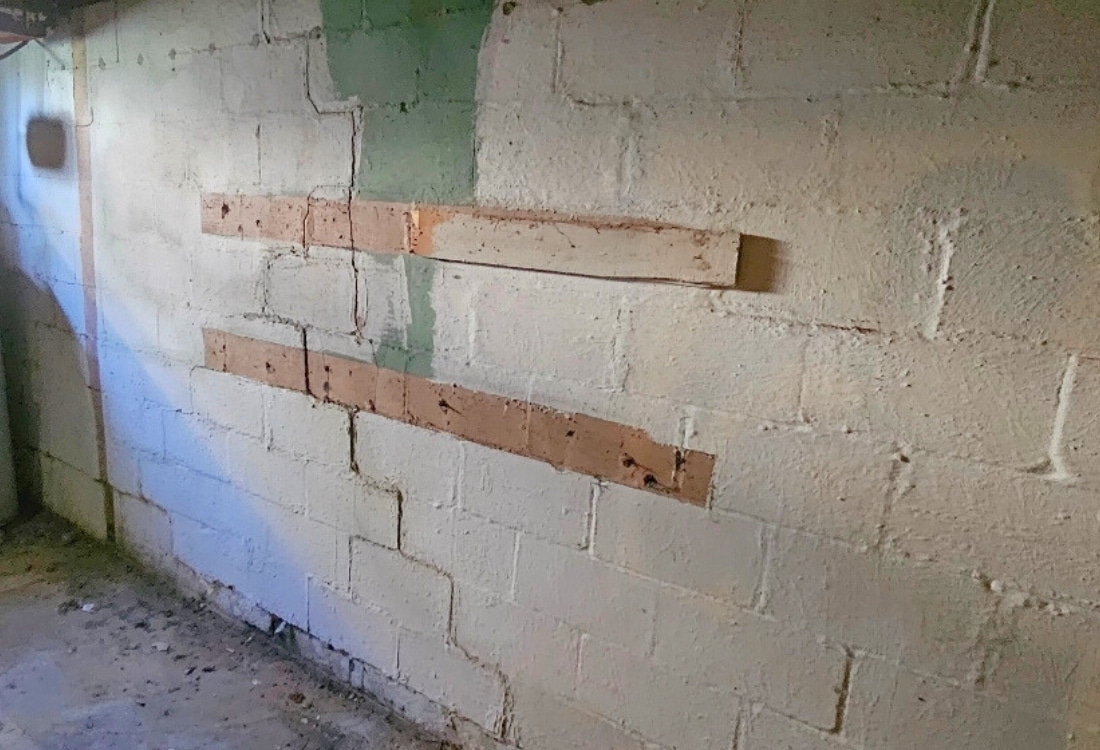 Bowed and cracked cinder block basement wall due to hydrostatic pressure before wall anchor installation in Berryville, VA.