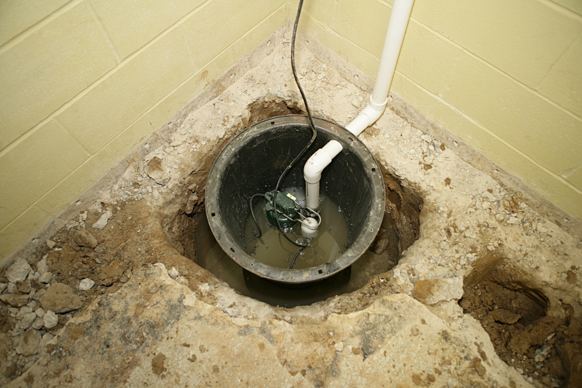 Non-functioning basement sump pump, illustrating poor drainage system in Gainesville, VA, leading to basement water seepage.