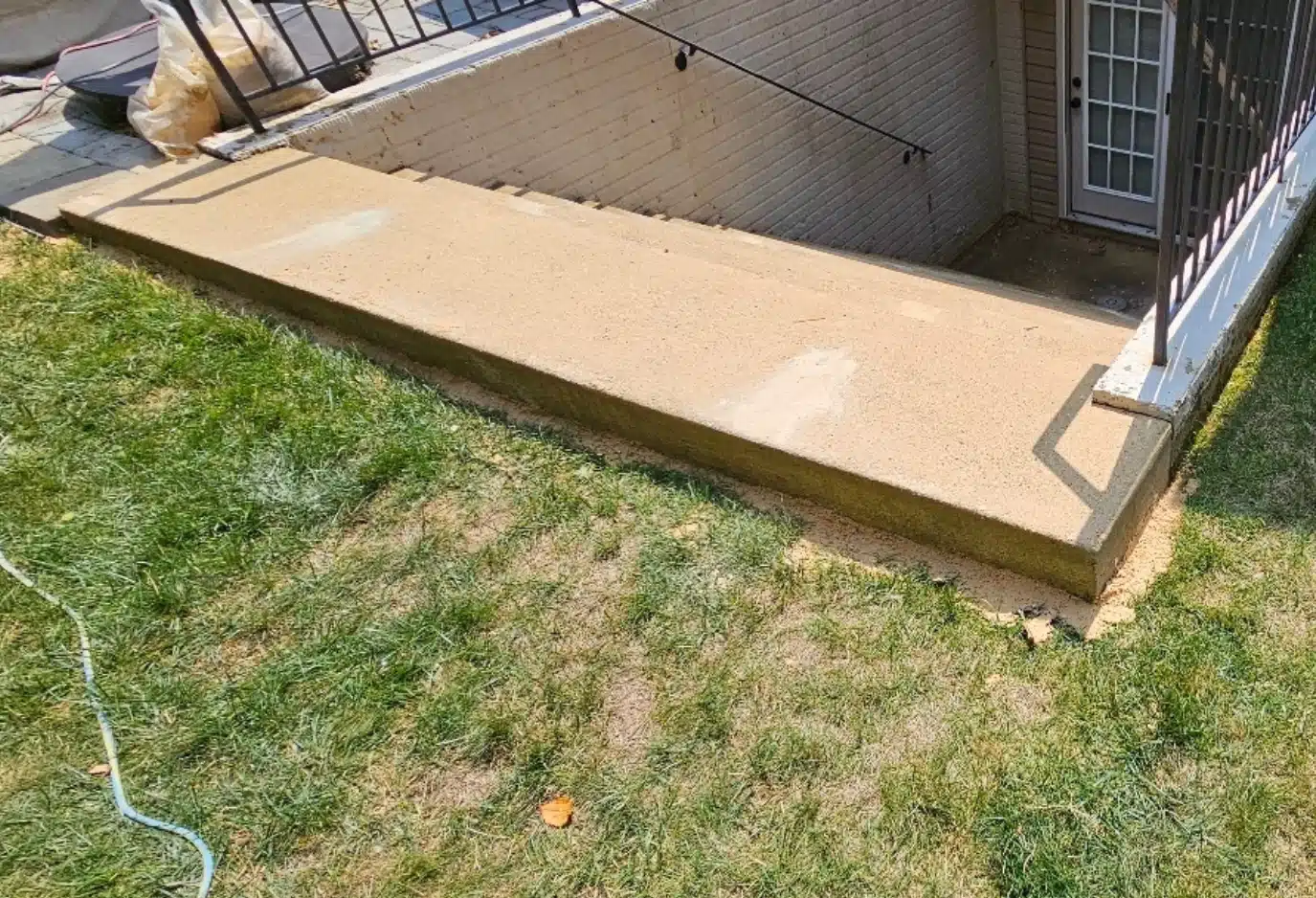 Stabilized stairway exit with reset pavers and filled voids after concrete void filling foam application in White Post, VA.