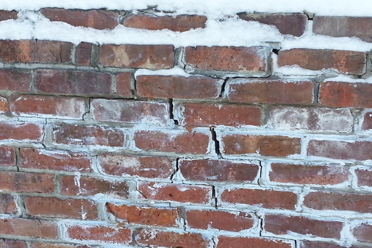 Foundation with visible cracks and sloped soil, showing how freeze-thaw cycles cause slope erosion in Flint Hill, VA.