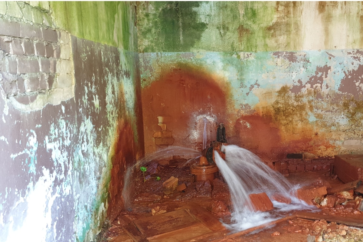 A burst plumbing pipe leaking water in the foundation, causing saturation and soil shifting in Front Royal, VA.