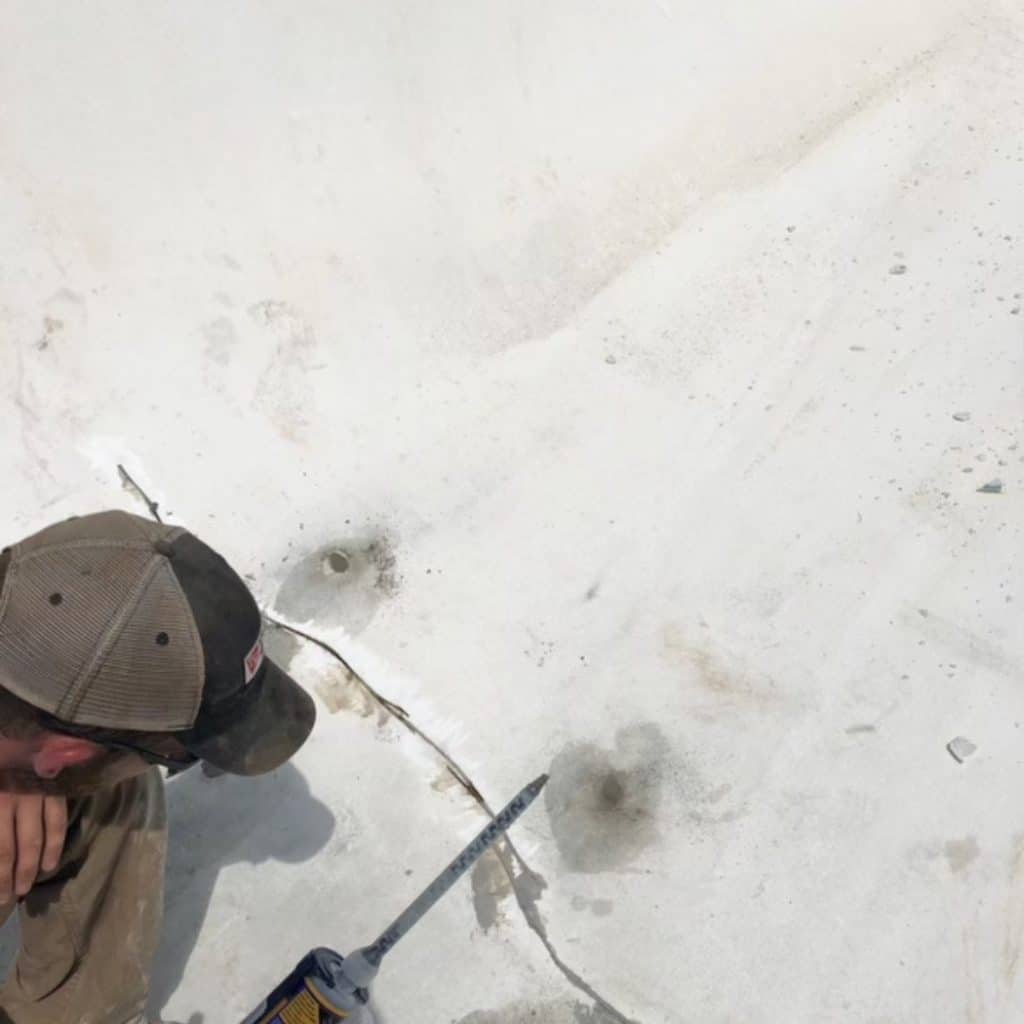 LUX team sealing cracks in the basement floor to prevent moisture infiltration and condensation in Martinsburg, WV.