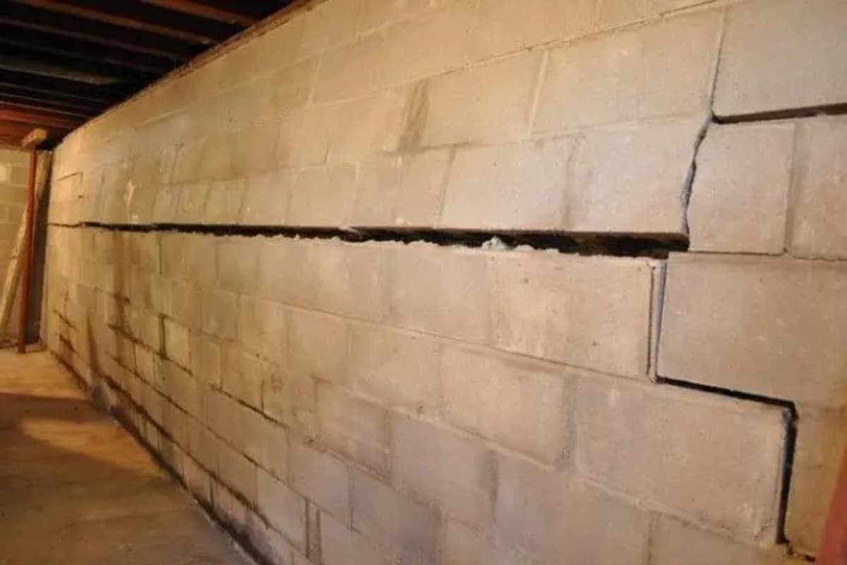 Severely bowing foundation wall caused by substandard materials, highlighting poor construction practices in Manassas, VA.