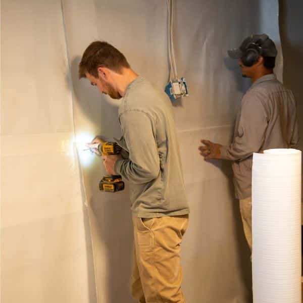 LUX team installing basement wall vapor barrier to protect against water infiltration during heavy rainfall in Southbridge, VA.