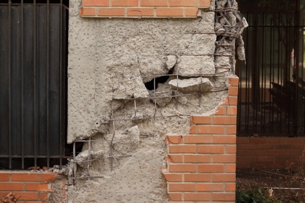 A crumbling foundation wall showing poor construction practices as a cause of structural instability in Winchester, VA.