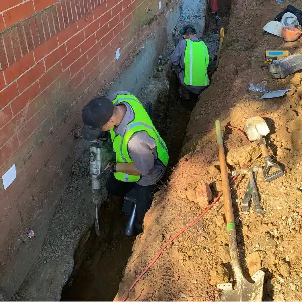 LUX team installing push piers to stabilize a sinking foundation damaged by a natural disaster in Charles Town, WV.