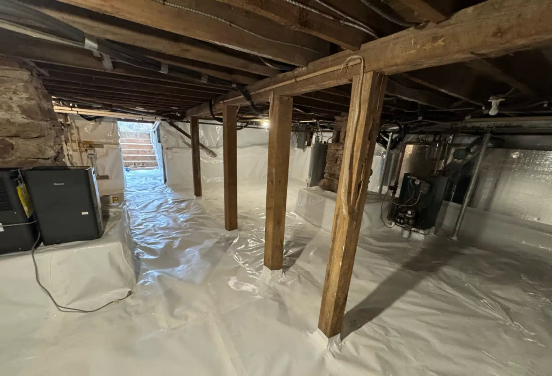 Encapsulated space with reinforced supports, vapor barrier, and insulation after crawl space restoration in Winchester, VA.