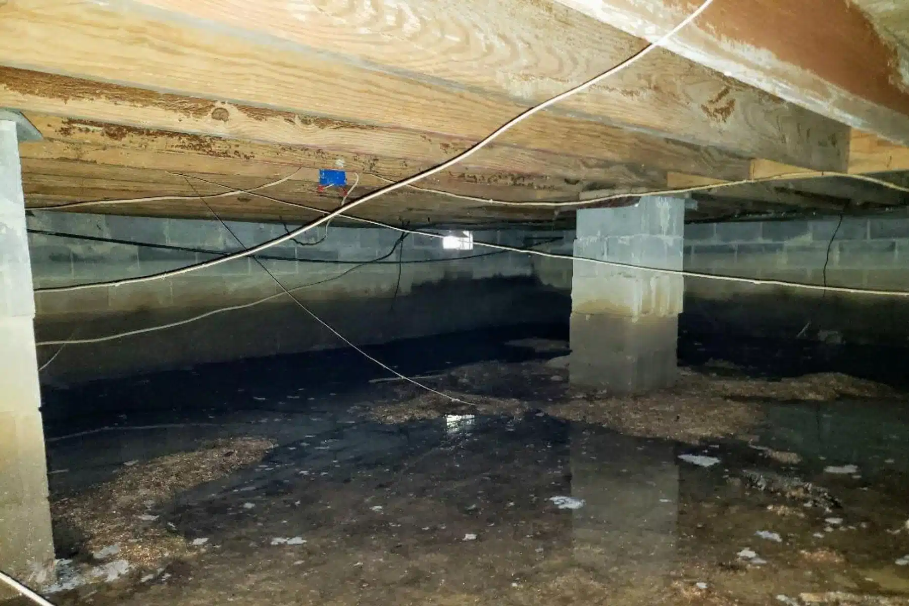 A flooded crawl space due to a poor drainage system causes crawl space issues during heavy rain in Fairfax, VA.