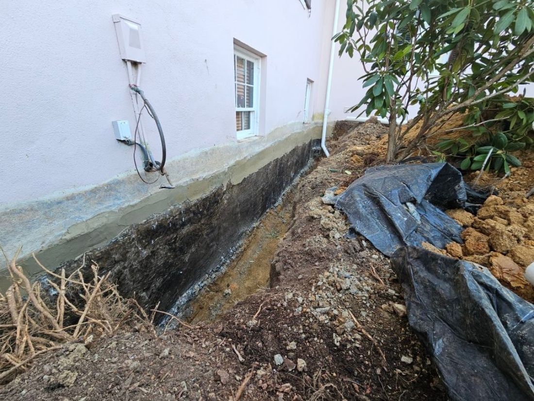 Excavation around the foundation of a historic home, preparing for exterior waterproofing installation in Linden, VA.