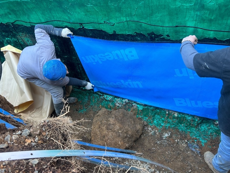 Rubber waterproofing membrane installation on foundation walls at an exterior waterproofing in Culpeper, VA.